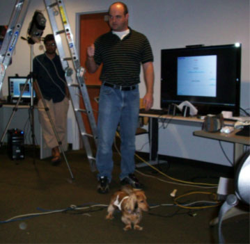 Pictured is the earliest proof of concept. The screen on the right is the game's interface and a projector is mounted on a tripod and a Wiimote is mounted higher in the environment on the ladder.